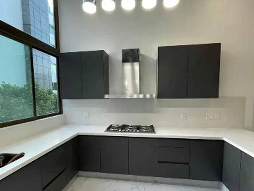 Cocina integral con cubierta de piedra, alacena a piso y campana integrada